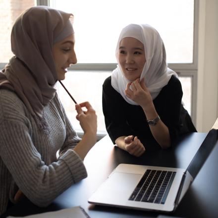 2 students checking a laptop together
