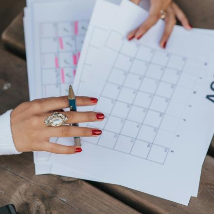 Calender with a hand holding a pen